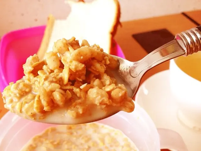 The picture consists of a table, on the table there are cup, saucer, bowl, spoon, bread, box and...