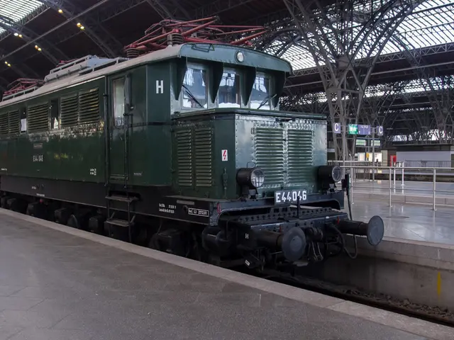 In this picture there is a train on the railway track. At the back there are boards and there are...