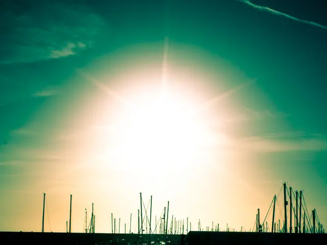 In this picture there are ships in the center of the image on the water and there is sun at the top...