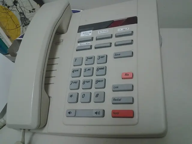In the picture we can see a telephone which is white in color with the buttons and it is placed on...