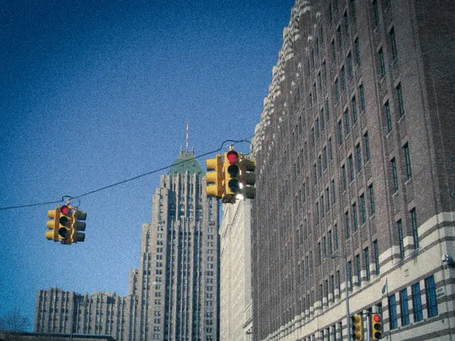 In this picture we can see few traffic lights, poles and buildings.