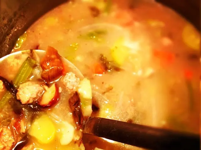 In this picture we can see the close view of the food. In the front there is a curry in the vessel...