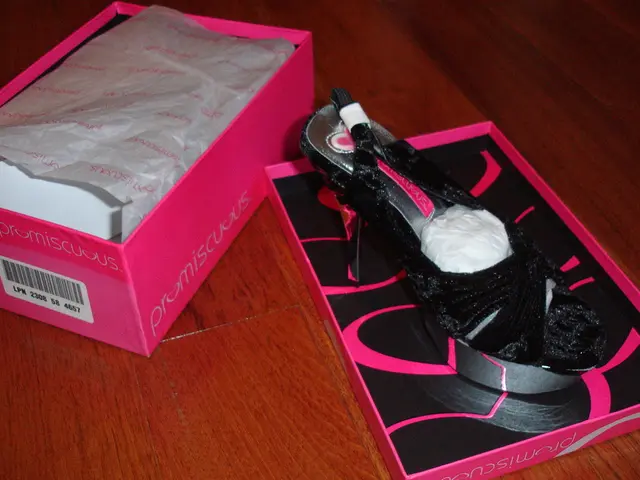 In this picture there is a sandal and its box in the center of the image, which are placed on a...