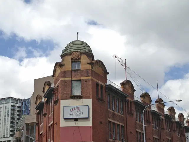 In the center of the image there are buildings. There is traffic signal. At the bottom of the image...